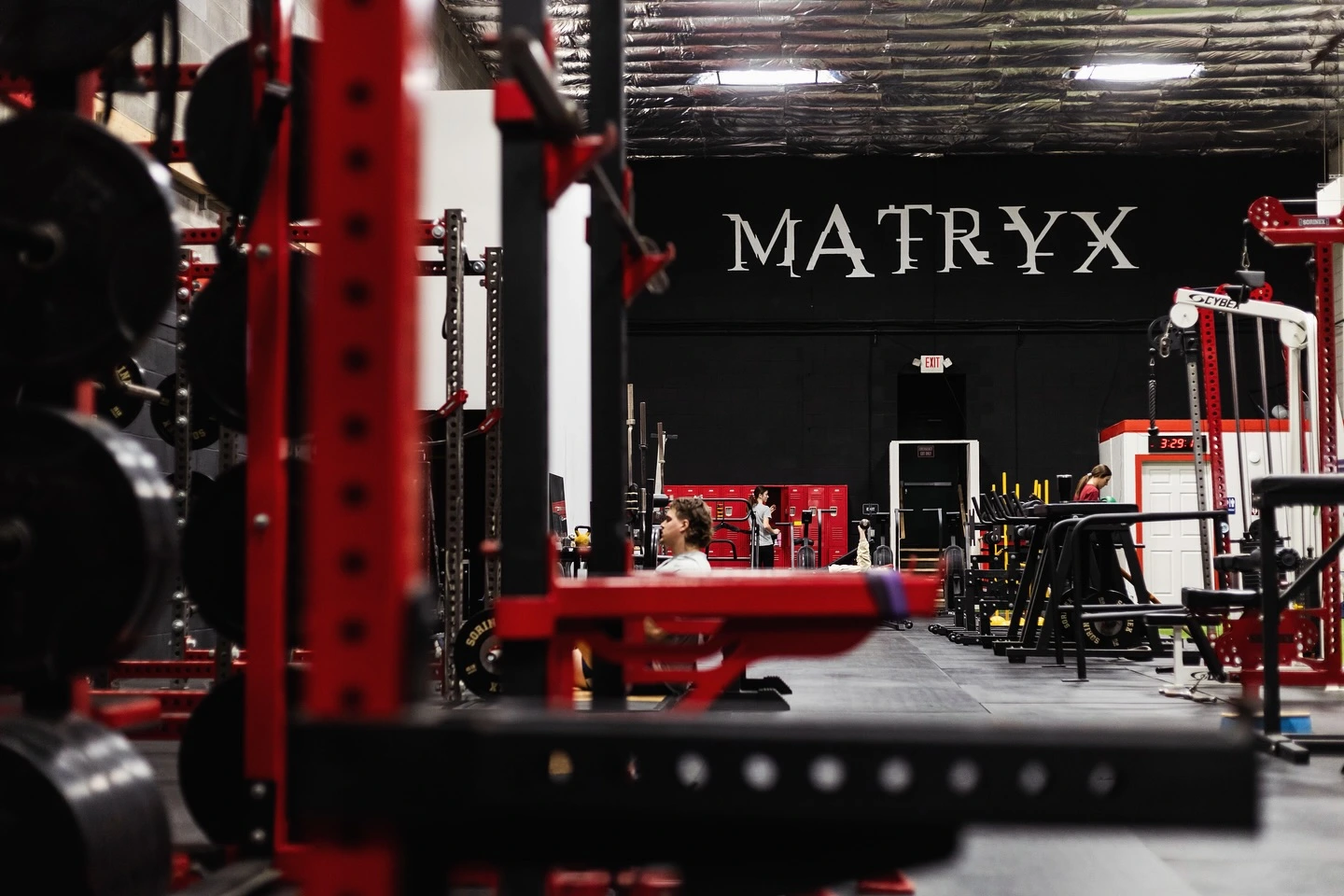 Matryx Performance Emmaus training floor with the MATRYX wordmark on the back wall and red power racks