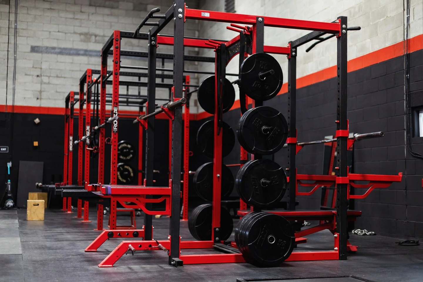 Matryx Performance Whitehall training floor with rows of red power racks and black plates